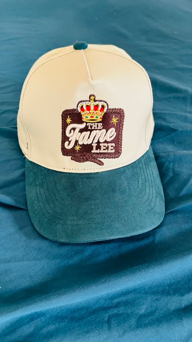 Cream baseball cap with embroidered crest patch and two-tone teal brim